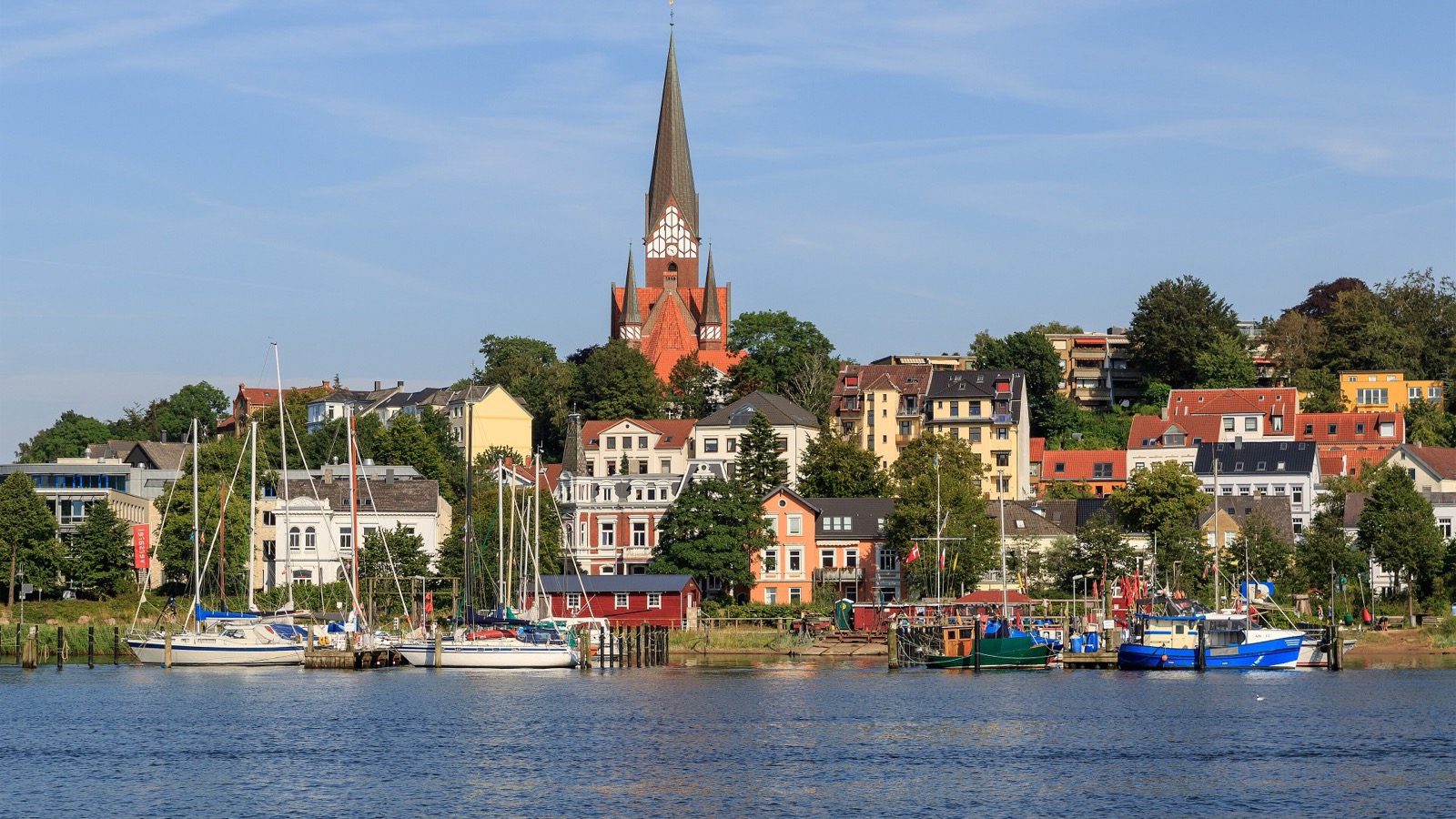 Blick über die Flensburger Förde mit Segelbooten auf Jürgensby und die St.-Jürgen-Kirche